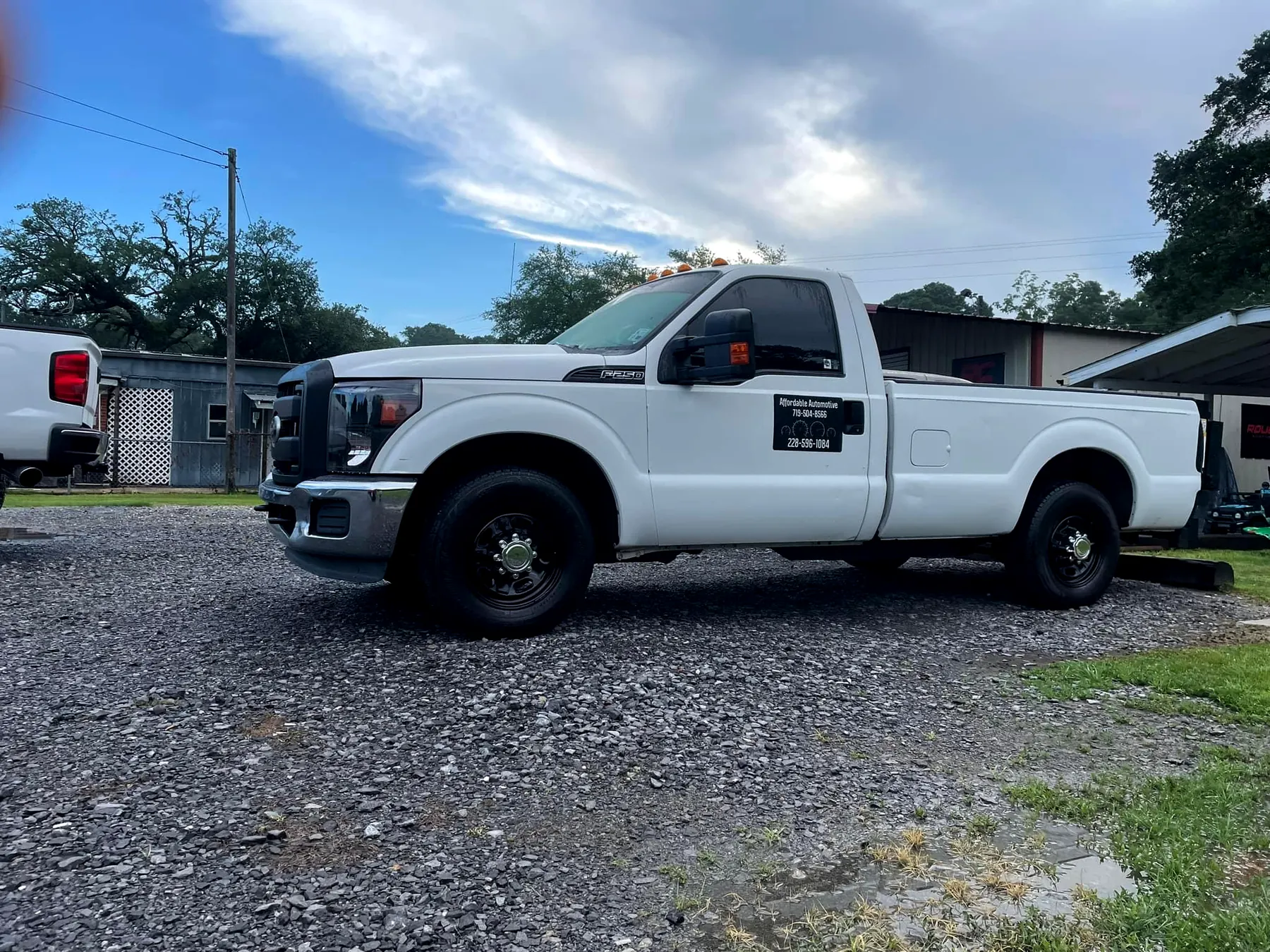 Our white Ford F-250 work truck, with Affordable Automotive and our phone number on the door