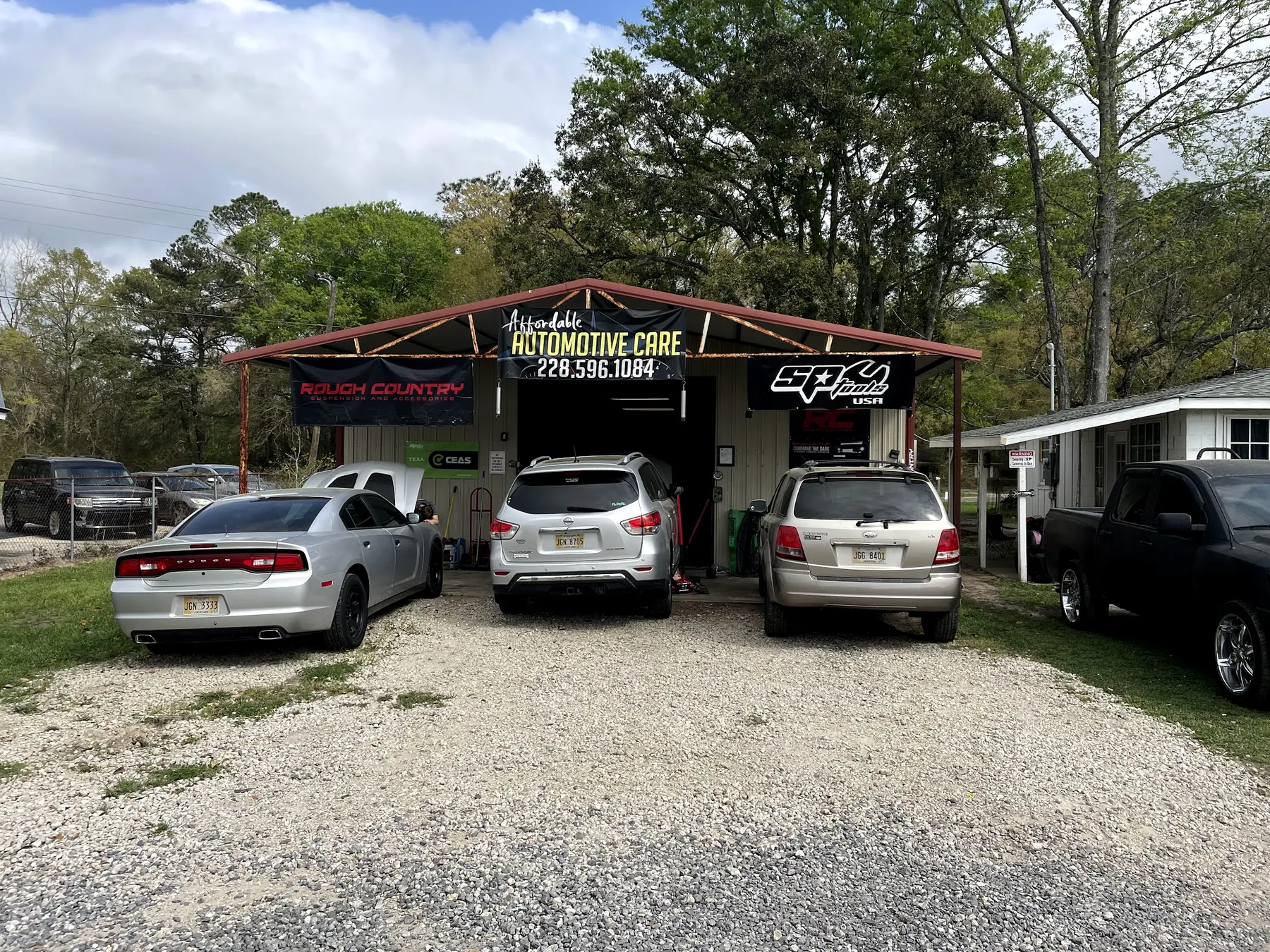 Our shop from the front, cars at the open bays under the Automotive Care sign