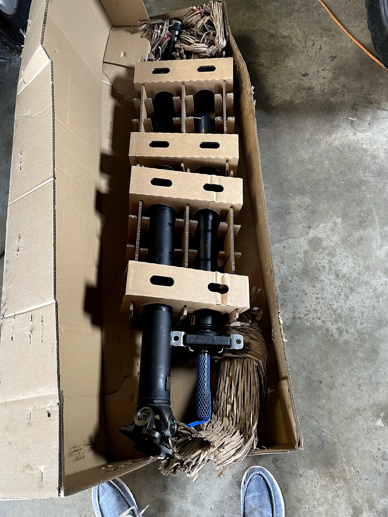 A lift kit's struts in their open box on our shop floor