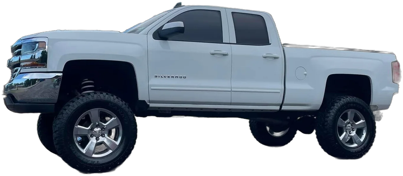 A white lifted Chevy Silverado with chrome wheels