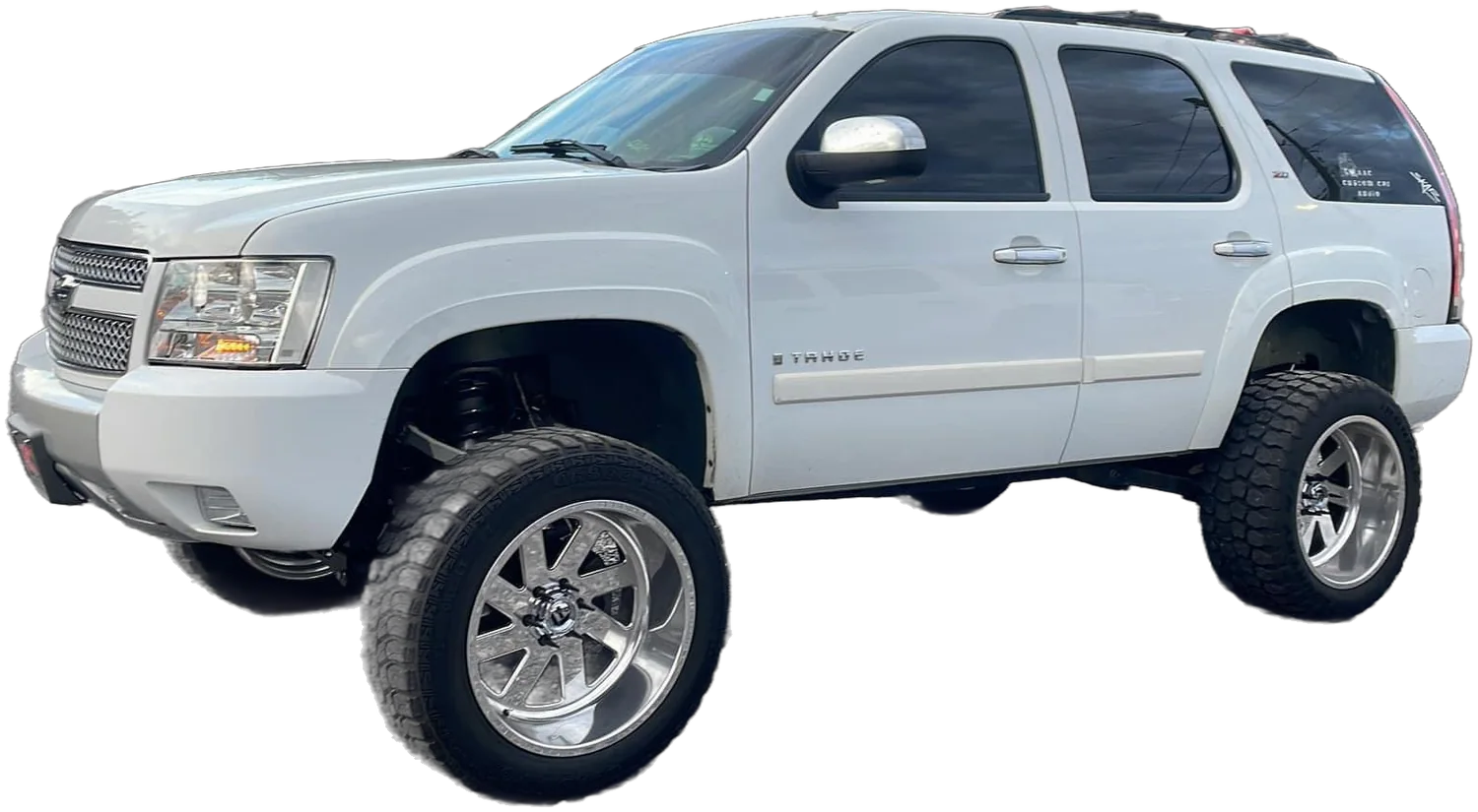A white lifted Chevy Tahoe on polished wheels